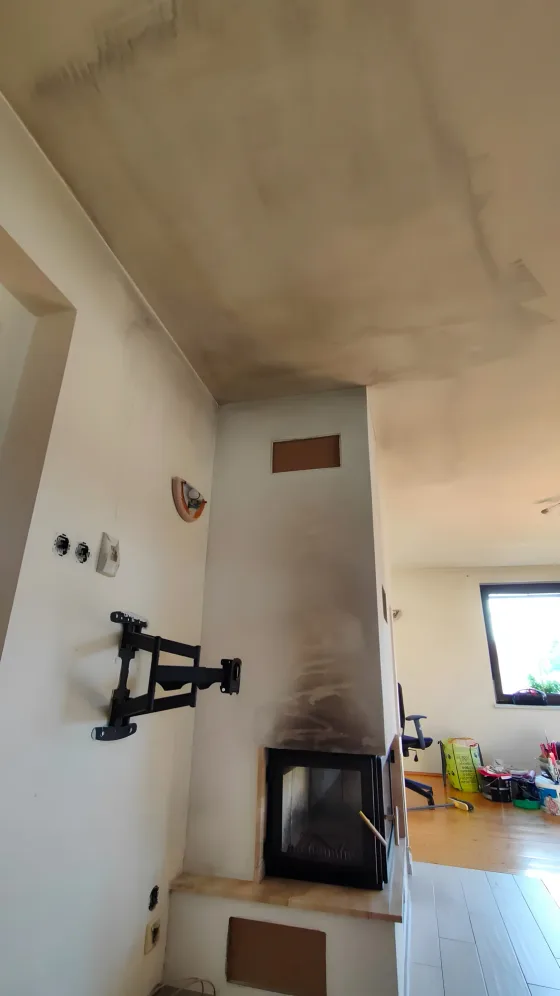 Šedý pruh sazí nad krbem a&nbsp;na stropě, stav před prací
